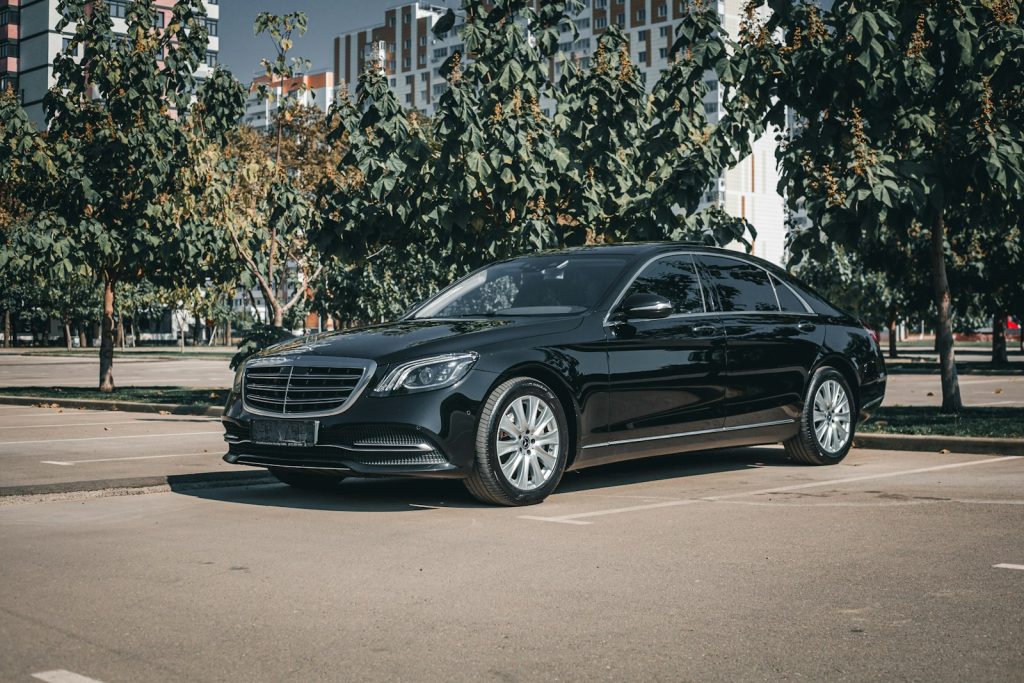 Luxury black mercedes-benz sedan parked in an urban setting.